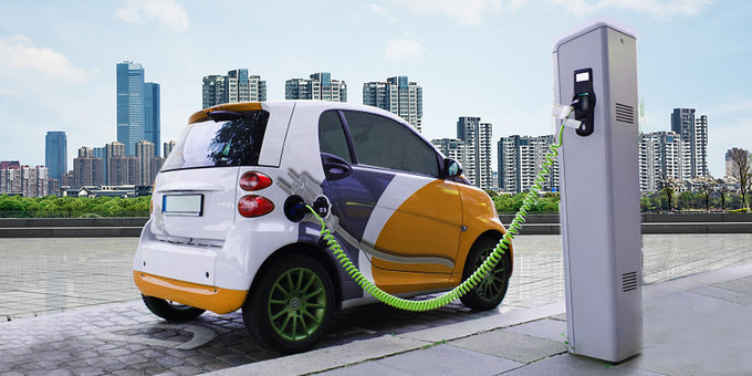 electric car attached to charger with the buildings at the background of car