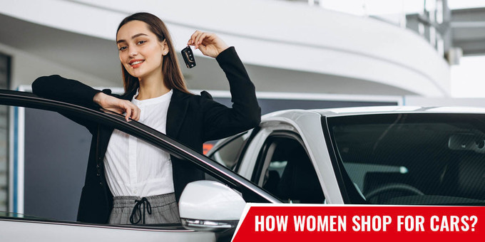 Standing woman with key in right hand is leaning her left hand on opened car door